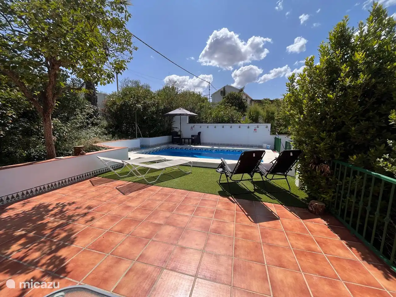 Gesamtübersicht über Schwimmbad und Sonnenliegen