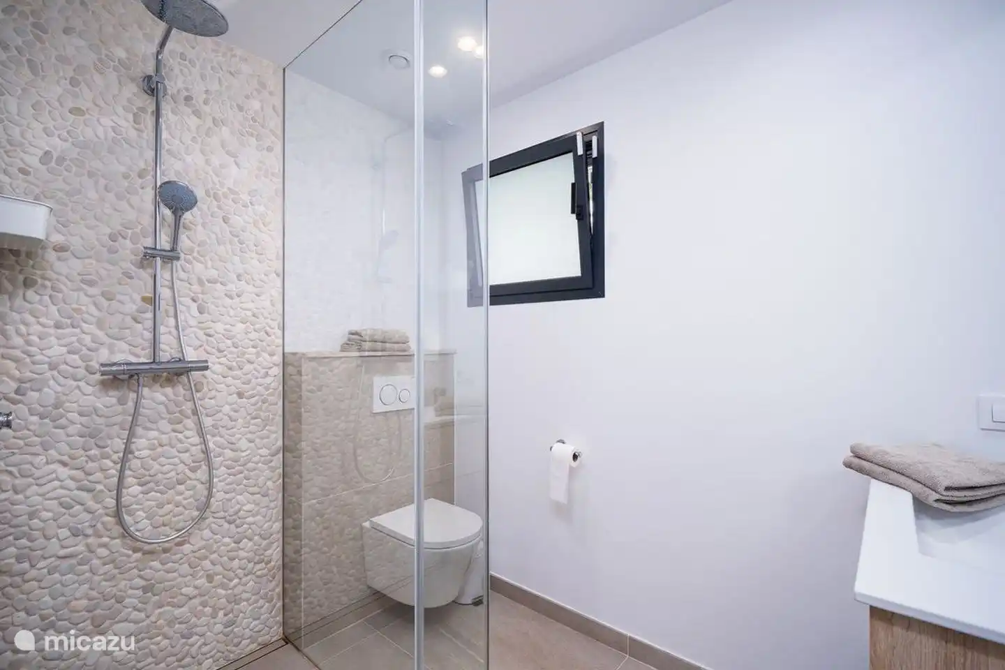 Die Villa verfügt über 2 Badezimmer mit Waschbecken und einer begehbaren Regendusche