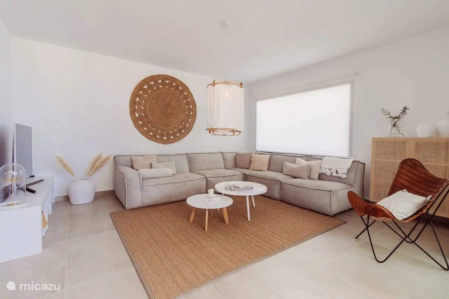 Das geräumige, helle Wohnzimmer verfügt über ein bequemes Ecksofa