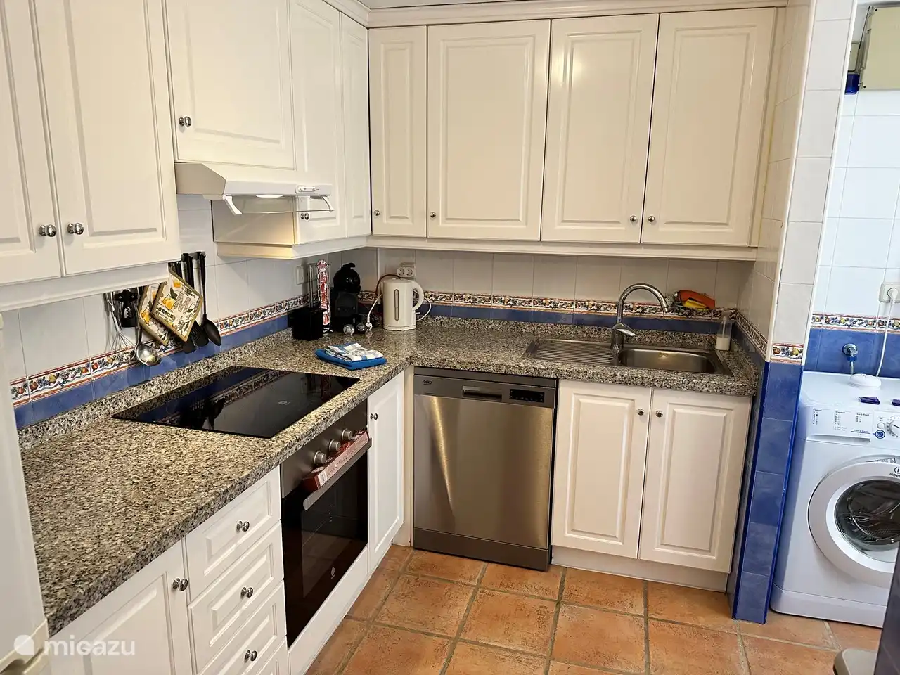 Cocina con lavavajillas y lavadero con lavadora y secadora.