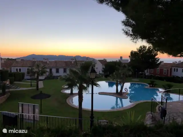Location de Vacances Espagne, Costa Blanca, Benidorm, maison mitoyenne - Casita El Mirador Vue du soir depuis le jardin et la table de jardin sur Benidorm et la mer.
