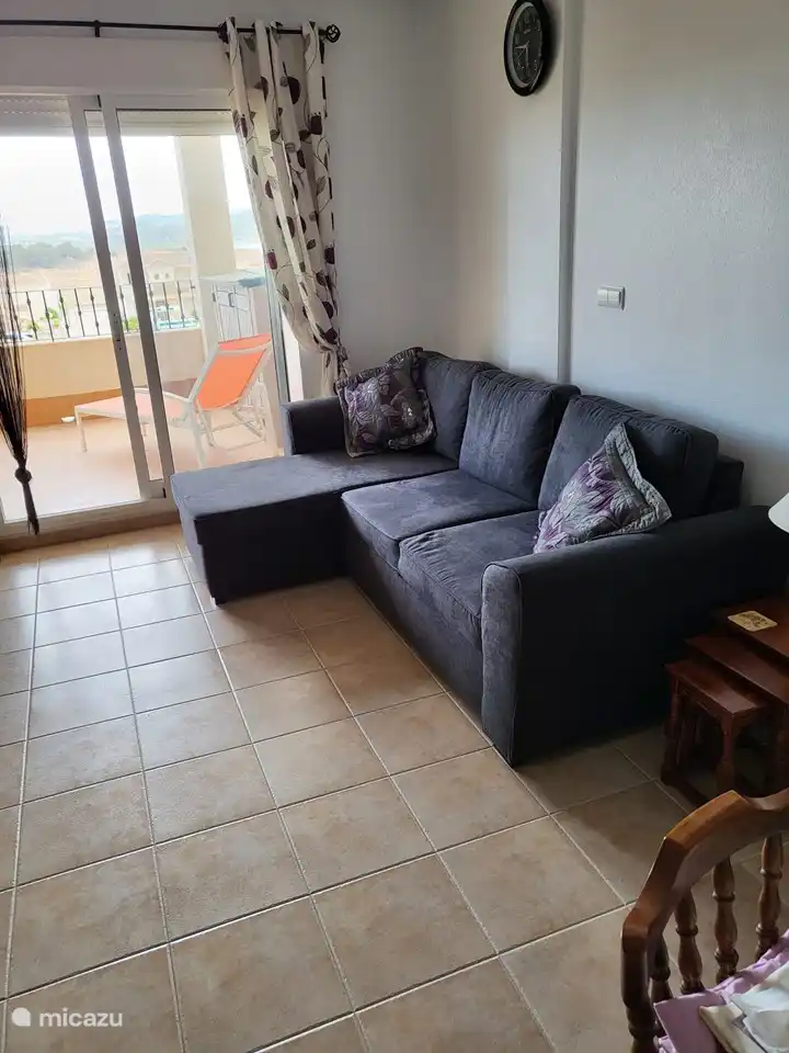 Vanuit de woonkamer stap je zo op het terras, vanaf deze bank kun je 's avonds lekker onderuit gaan met een boek, of je zit op het terras te genieten van het klimaat.