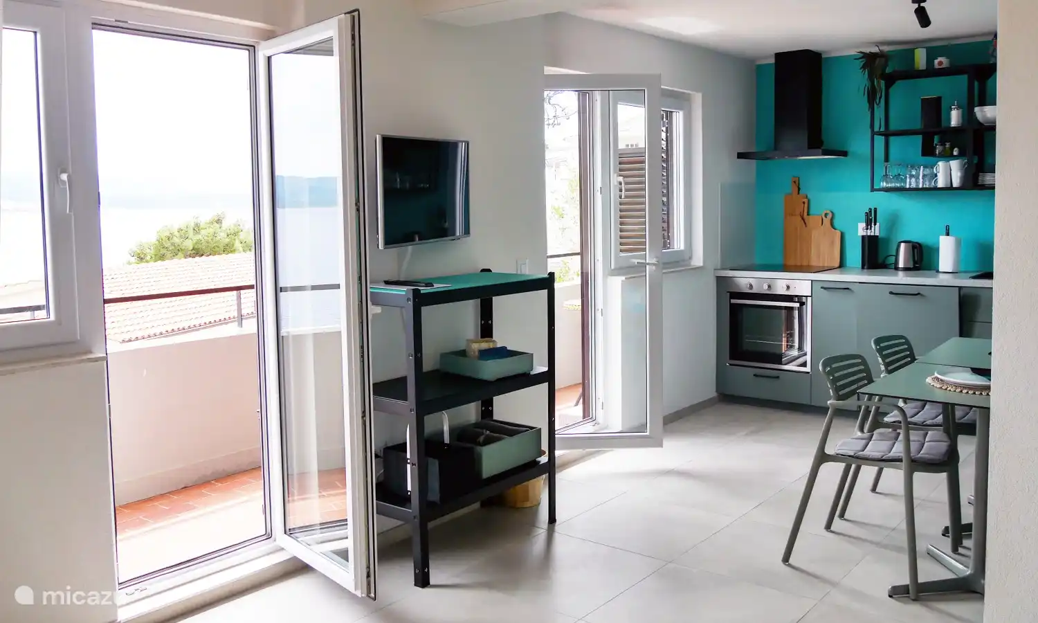 Die zwei Fenster und zwei Terrassen­türen sorgen für eine licht­durch­fluteten Wohn­bereich. Auf dem breiten Balkon hat man einen hervorragenden Blick auf das Meer.