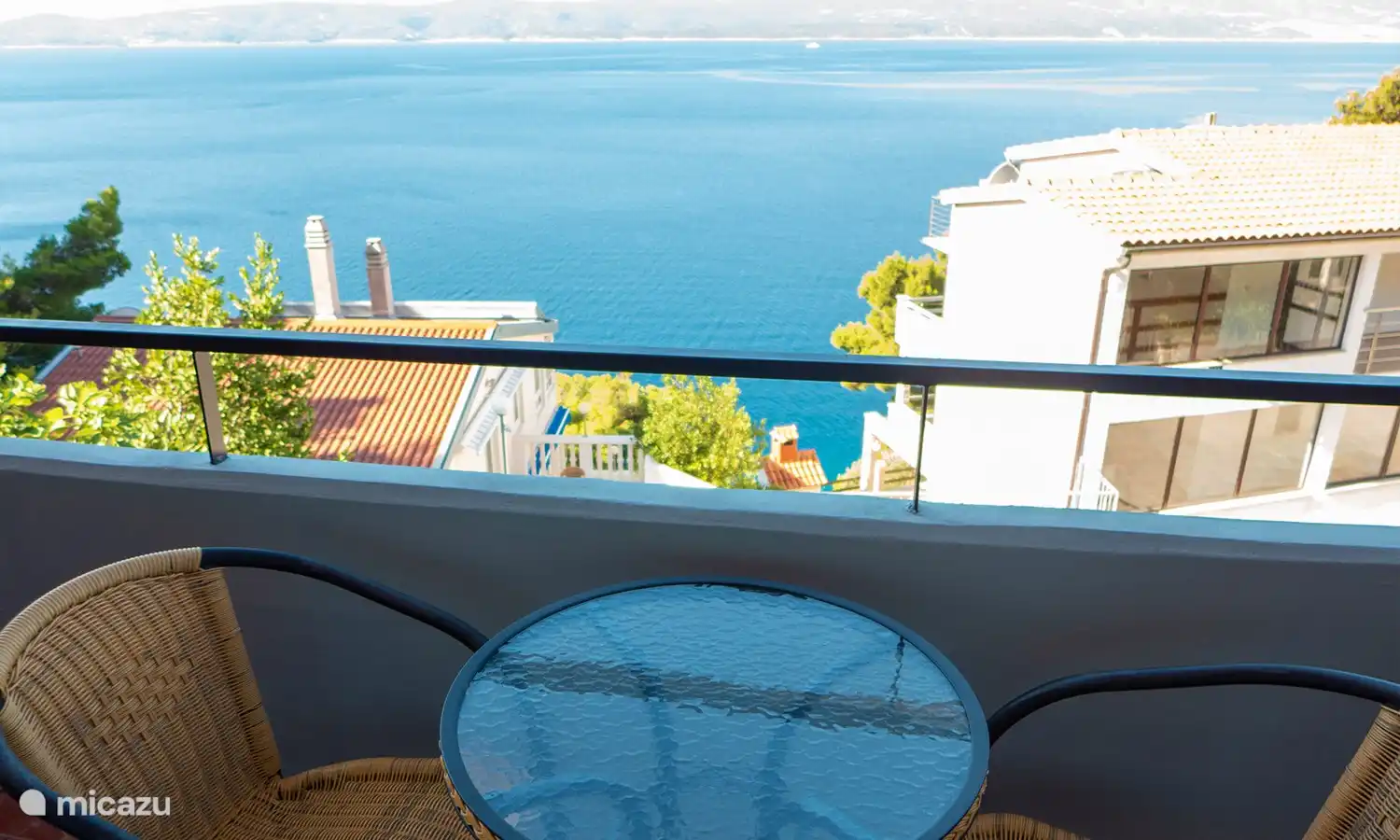 Das Apartment verfügt über einen Balkon, der mit zwei Tischen, vier Stühlen, einem Sonnenschirm und einer Sonnenliege ausgestattet ist. Von hier aus genießt man eine herrliche Aussicht auf das glitzernde Meer – ideal für entspannte Stunden.