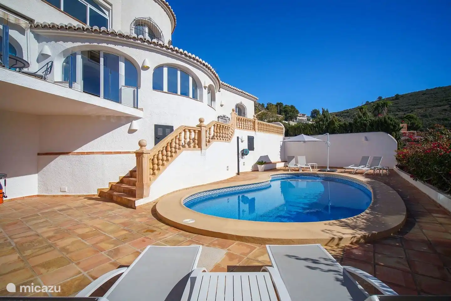The terrace around the private pool of Villa Bahia del Portet has several sunbeds