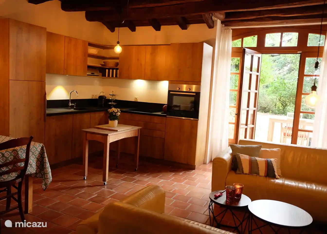 Küche mit gemütlicher Sitzecke und Terrassentüren zur Terrasse.