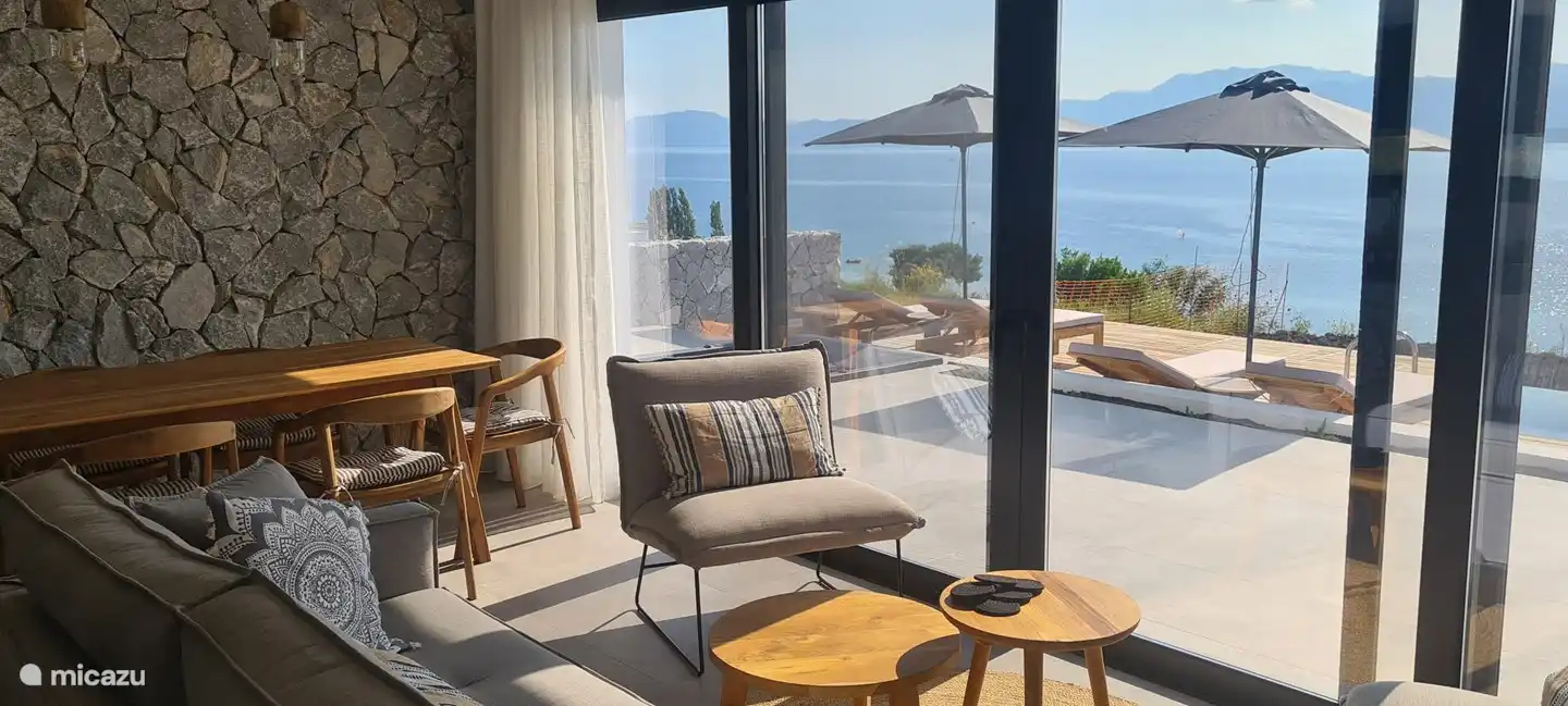 Wohnzimmer mit durchgehender Glasfront mit Meerblick