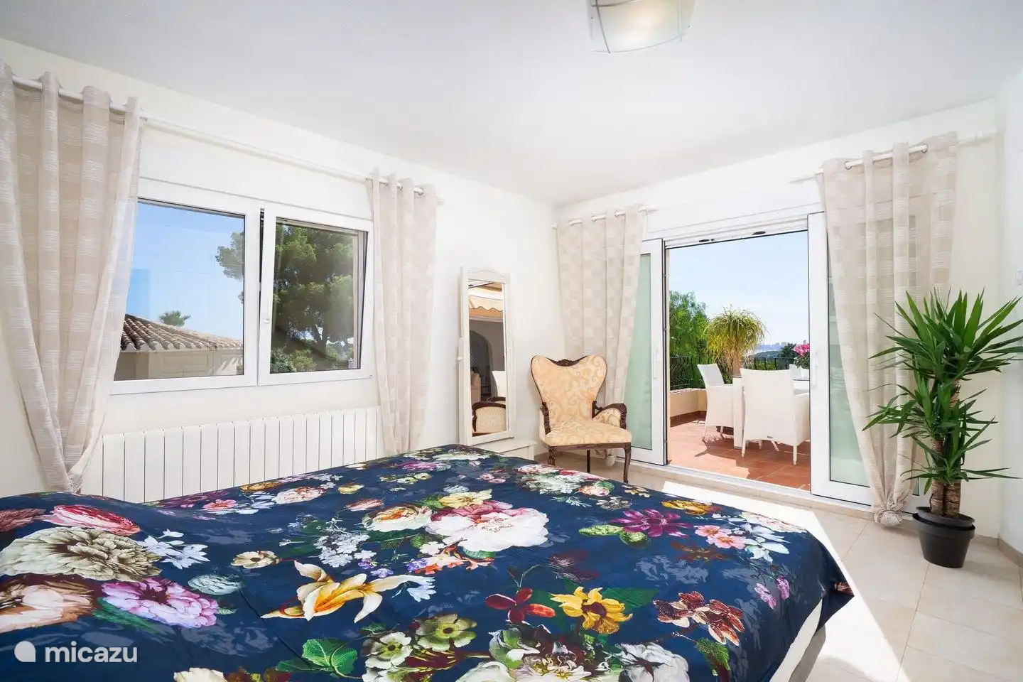 El dormitorio principal de Villa Rosana tiene puertas correderas a la terraza y baño privado.