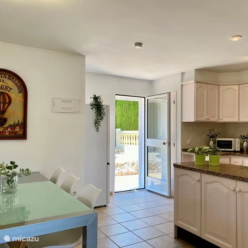 The spacious open kitchen also has a dining table and gives access to the Mediterranean garden