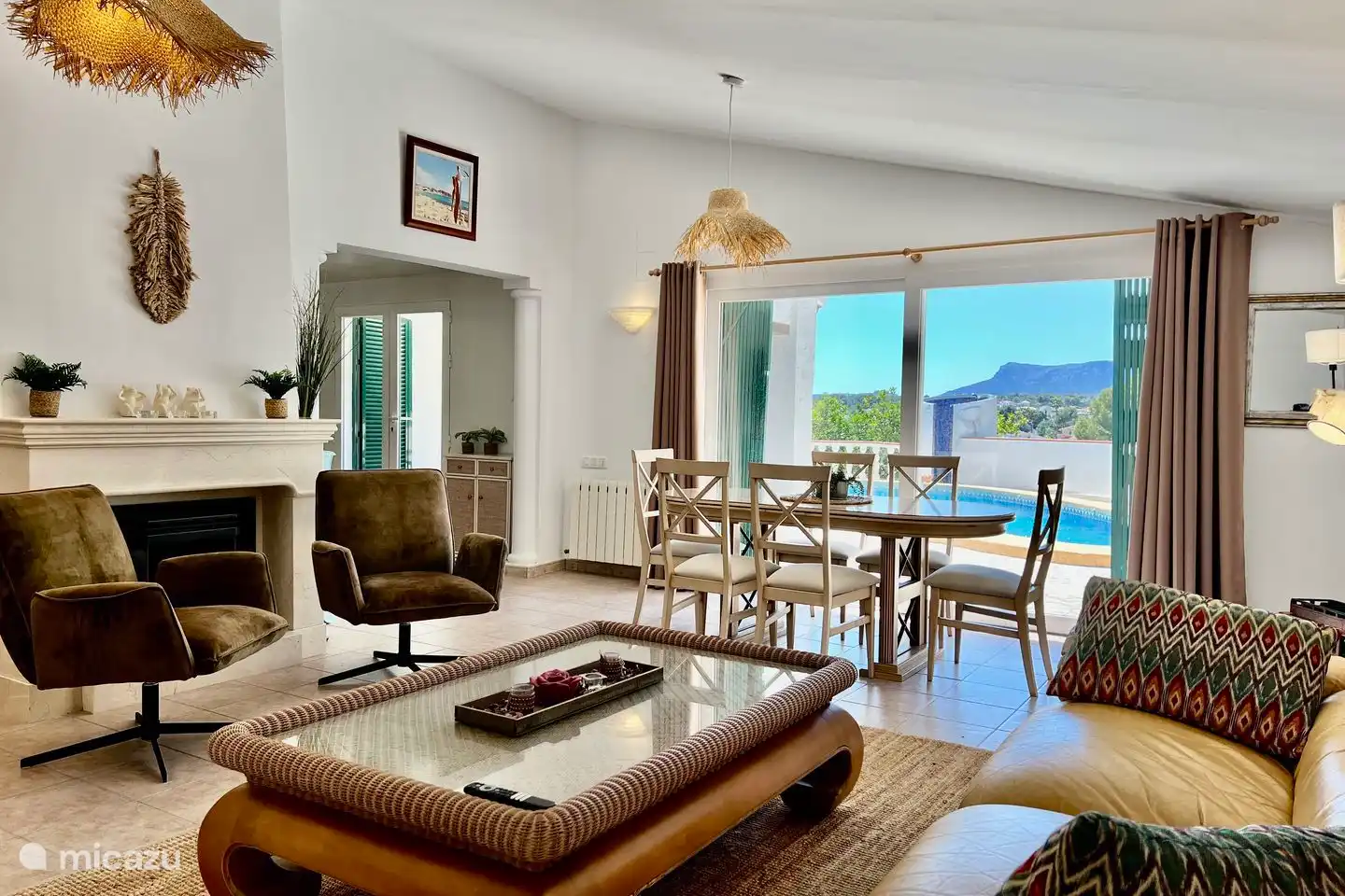 Lichte woonkamer met grote schuifdeuren naar het zonnige terras met privé zwembad.