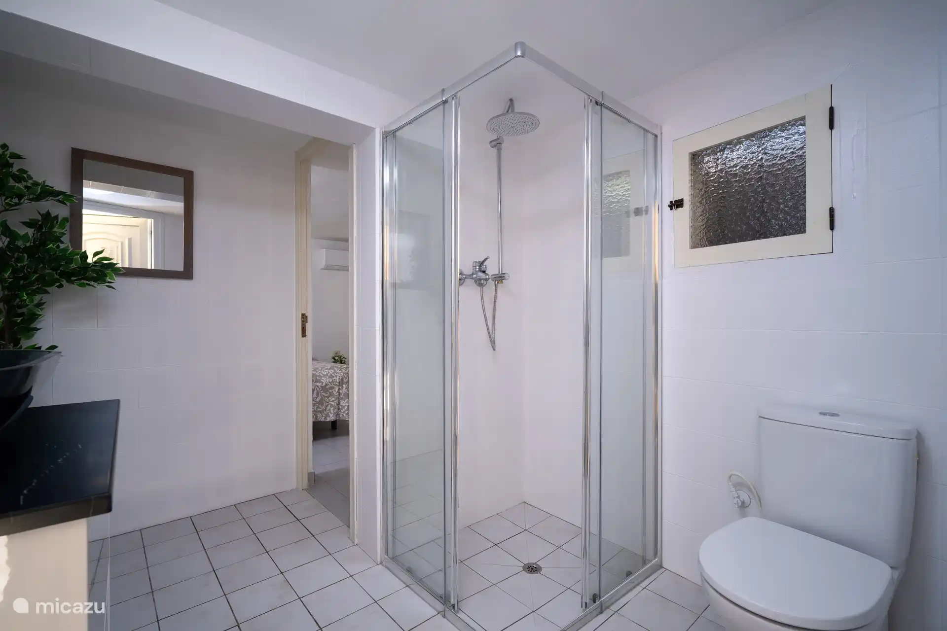 Badkamer op de begane grond met aansluitend de vierde slaapkamer.