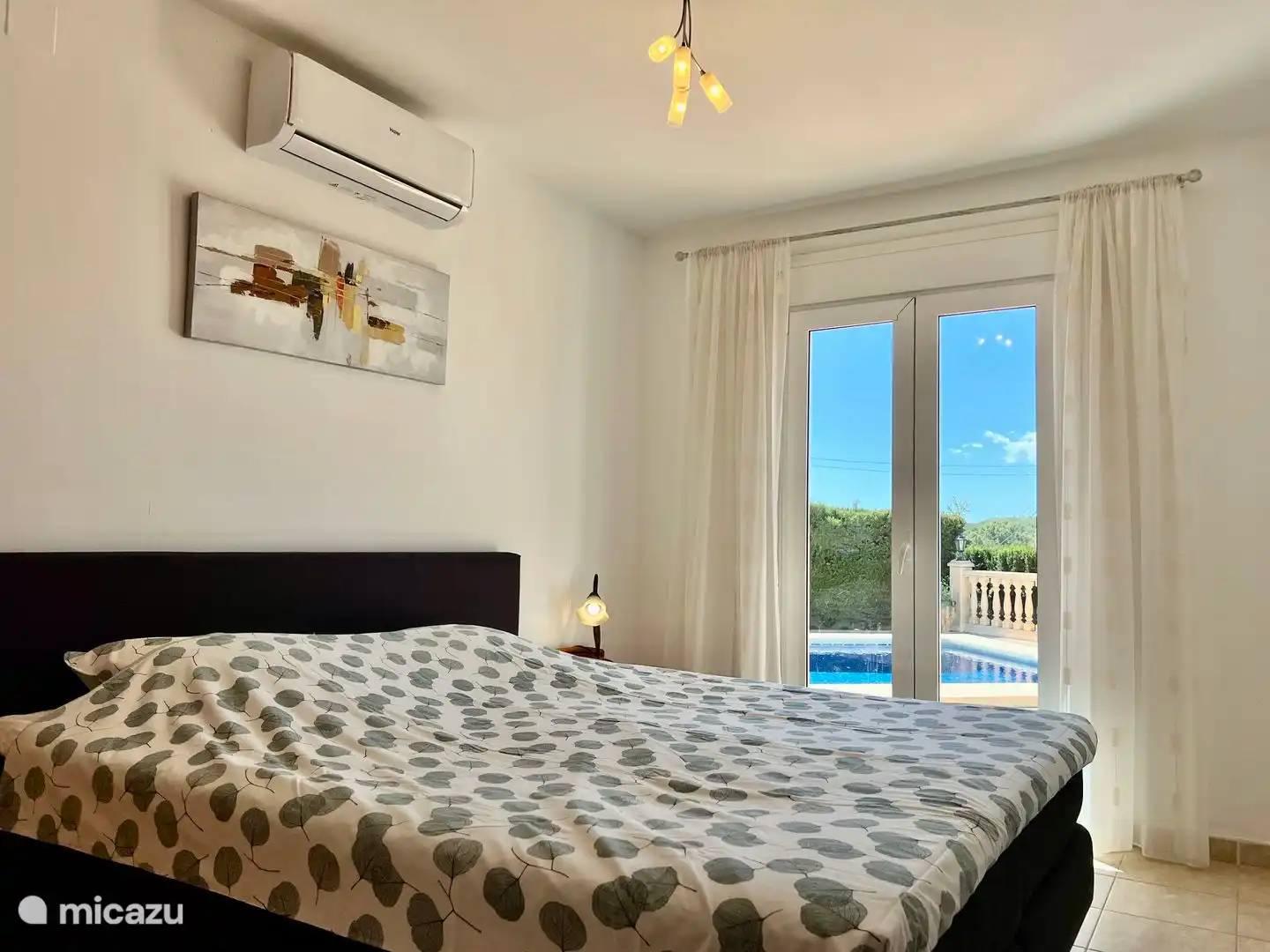 Das Hauptschlafzimmer der Villa Maia hat ein Boxspringbett von 180 x 200 cm mit Terrassentüren zur Terrasse.