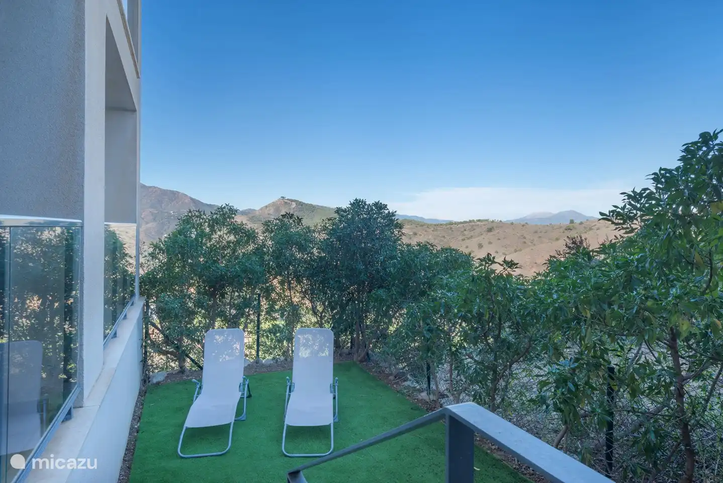 Privétuin met twee relaxbedden en mooi uitzicht op de bergen. 