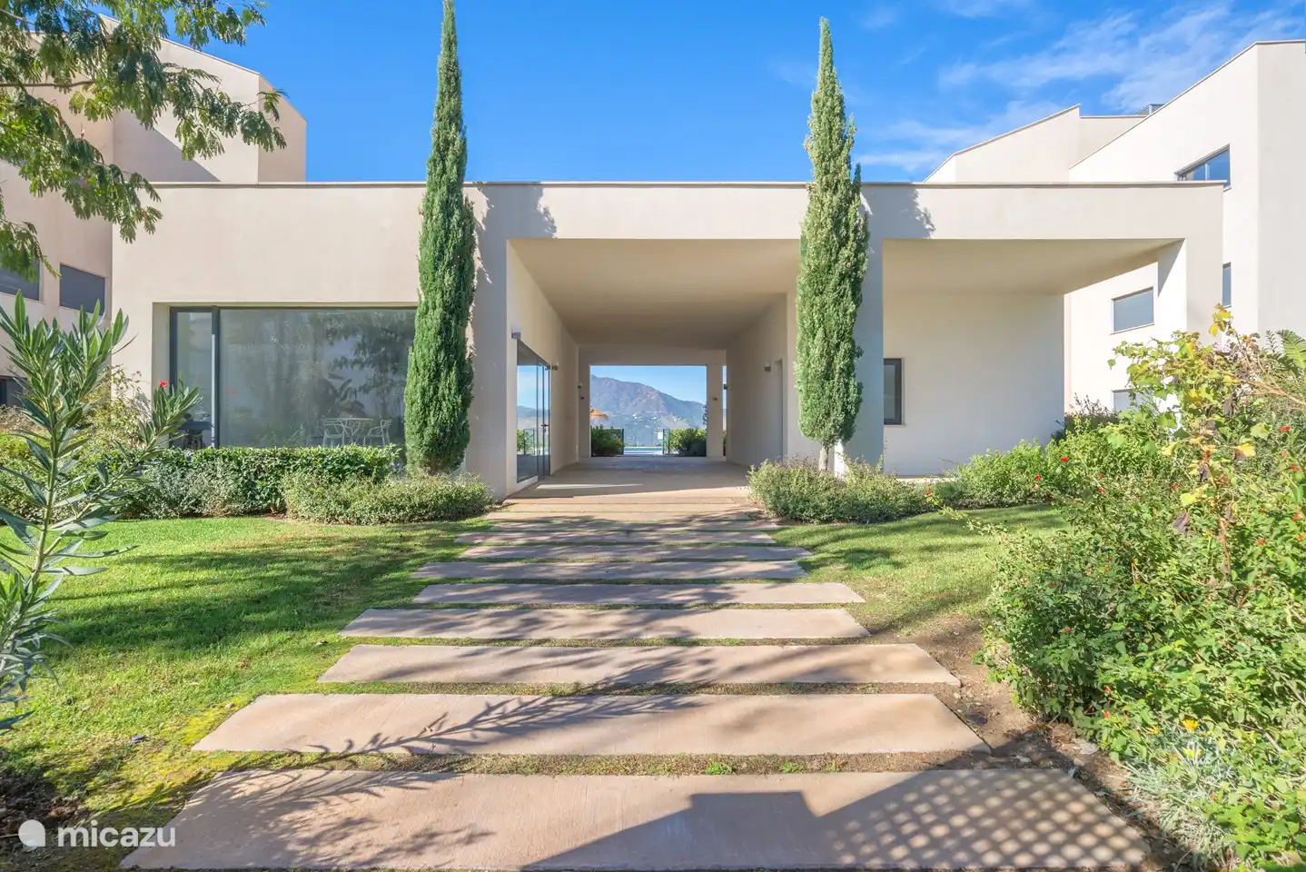Gezamenlijke tuin met uitzicht op he zwembad en de bergen.