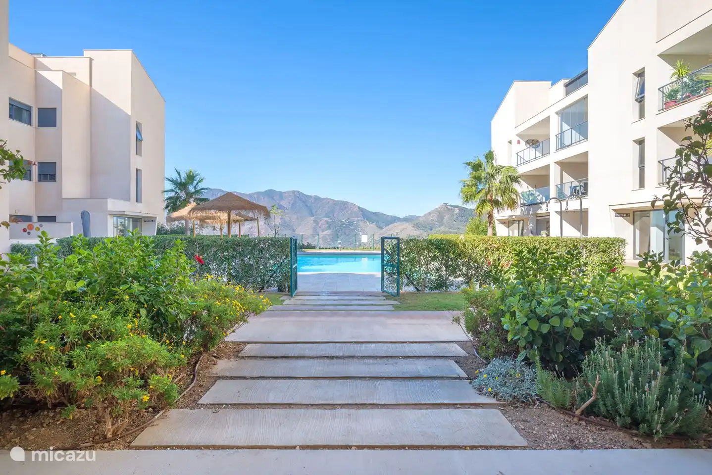 Ingang naar het gezamenlijke zwembad met uitzicht op de bergen