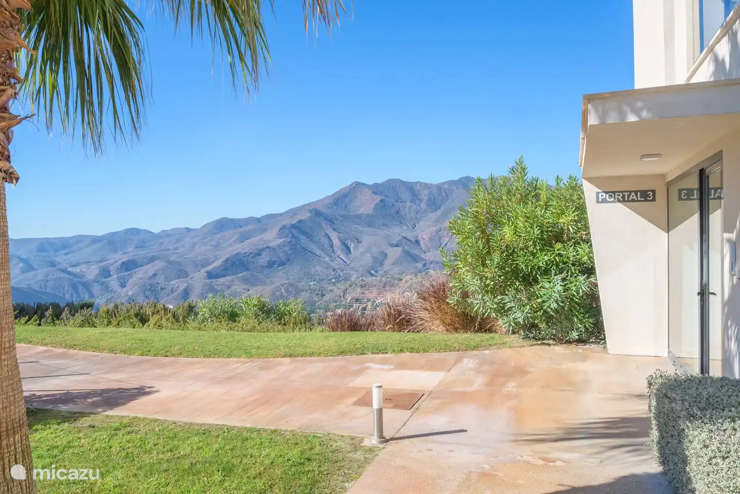 Tuin rondom het zwembad met uitzicht op de bergen.