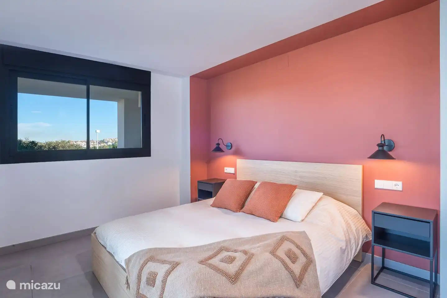 Slaapkamer met tweepersoonsbed, inbouwkast, en-suite badkamer en terras met uitzicht op de bergen.