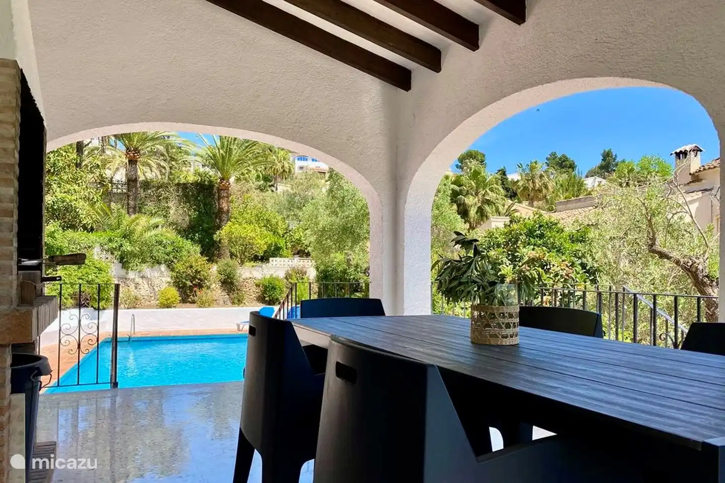 The covered terrace of Villa Olivera overlooks the swimming pool