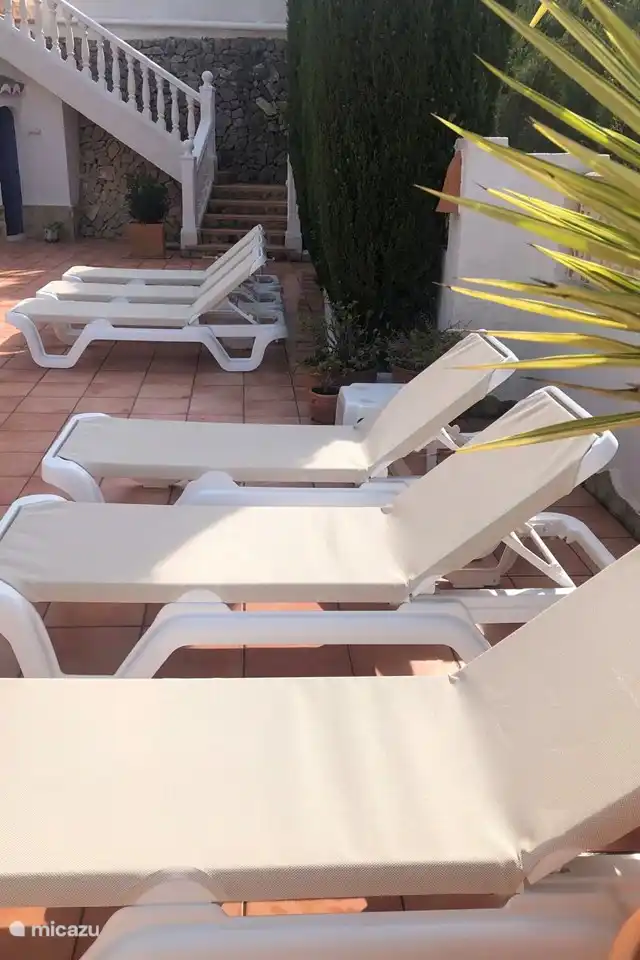 Il y a plusieurs transats autour de la piscine privée de la Villa Juntos