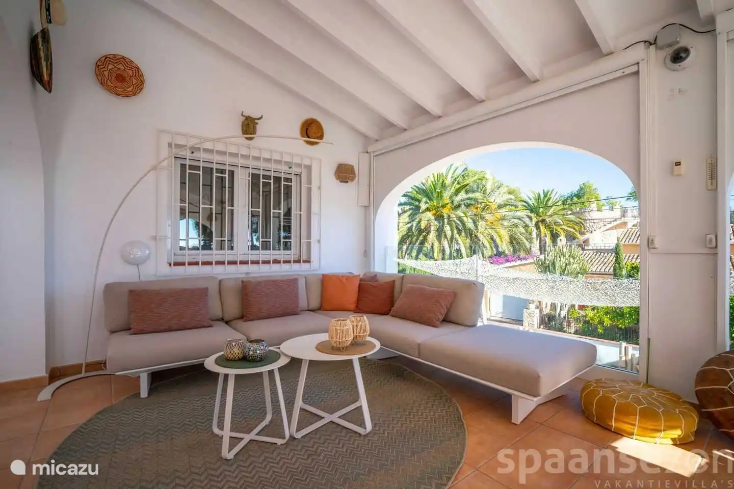 Overdekte loungehoek met zicht op het privé zwembad