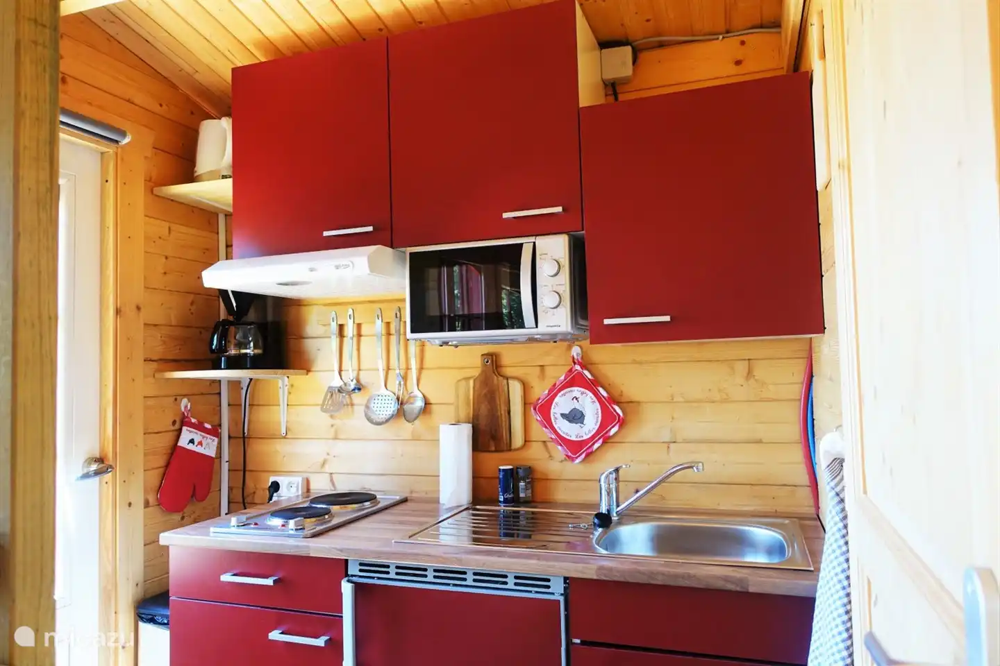 La cocina/área de cocción con nevera/congelador, microondas y vitrocerámica doble.