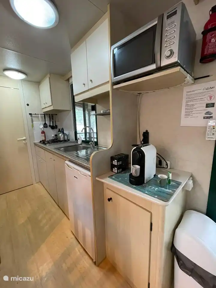 Voll ausgestattete Küche mit 4-Flammen-Gasherd, Mikrowelle und Nespresso-Maschine.