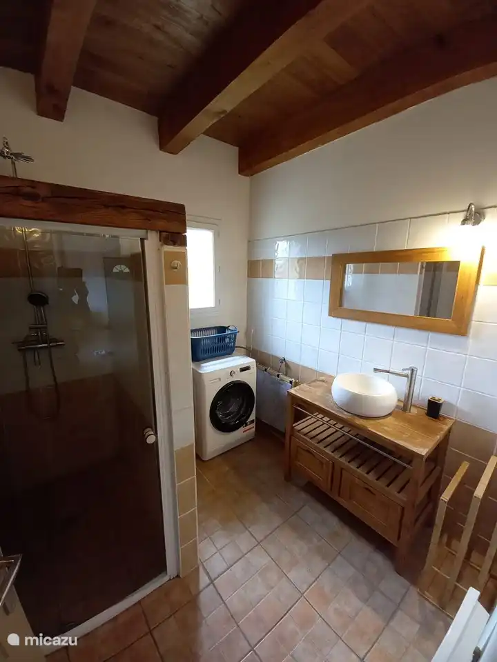 cuarto de baño con plato de ducha, lavabo y lavadora