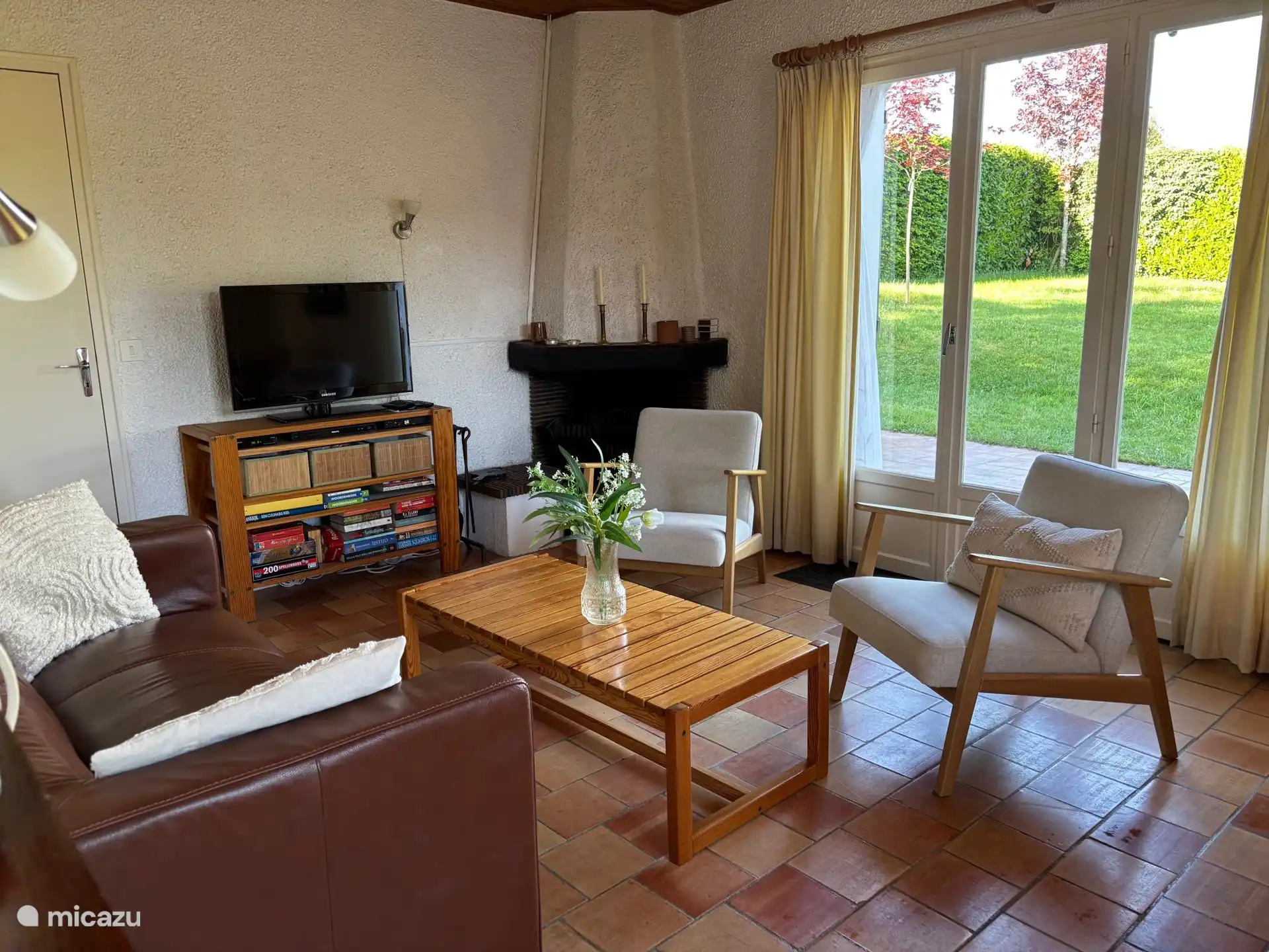 Gemütliches Wohnzimmer mit Kamin und Terrassentüren zum Garten