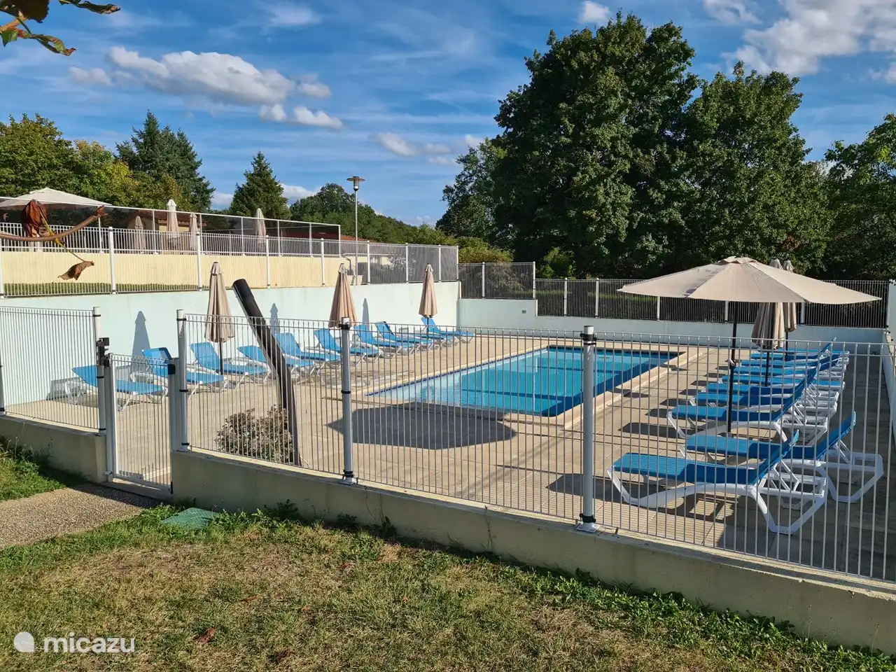 Geschlossenes Planschbecken mit Sonnenliegen und Sonnenschirm