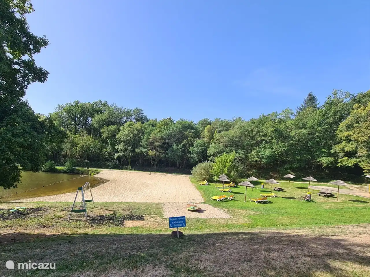 Strand mit Liegestühlen am See und Spielplatz für die Kinder
