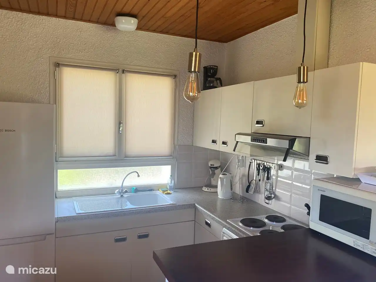 Küche mit kompletter Ausstattung, Kombi-Mikrowelle, großem Kühlschrank mit Gefrierfach und Elektroherd.