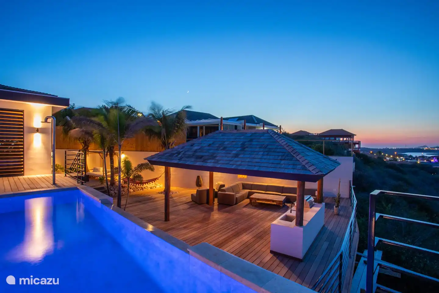 Overview of the chill area with outdoor kitchen in the evening.