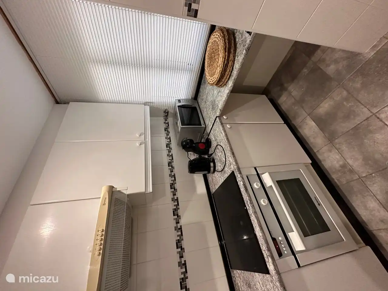 Küche mit Elektroherd, Mikrowelle, Dolce-Gusto-Kaffeemaschine und Wasserkocher