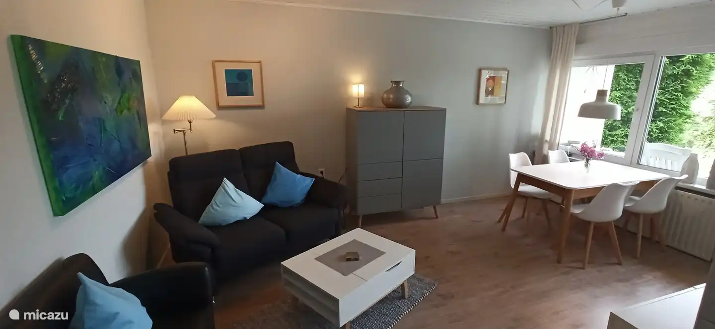 Wohnzimmer mit Doppelsitzer Couch und 2 Sesseln.