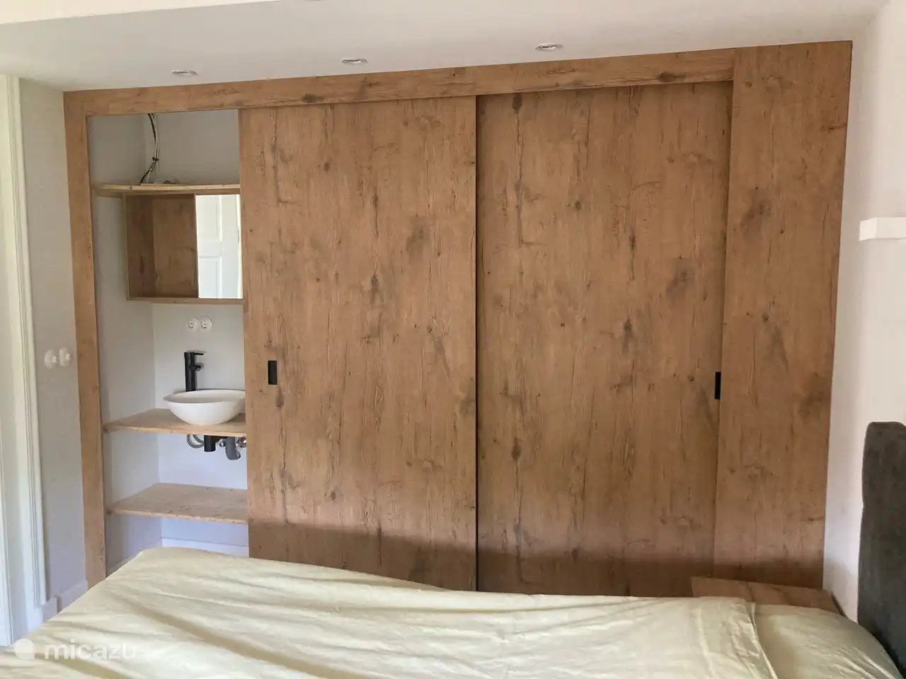 Bedroom with spacious wardrobe and sink.