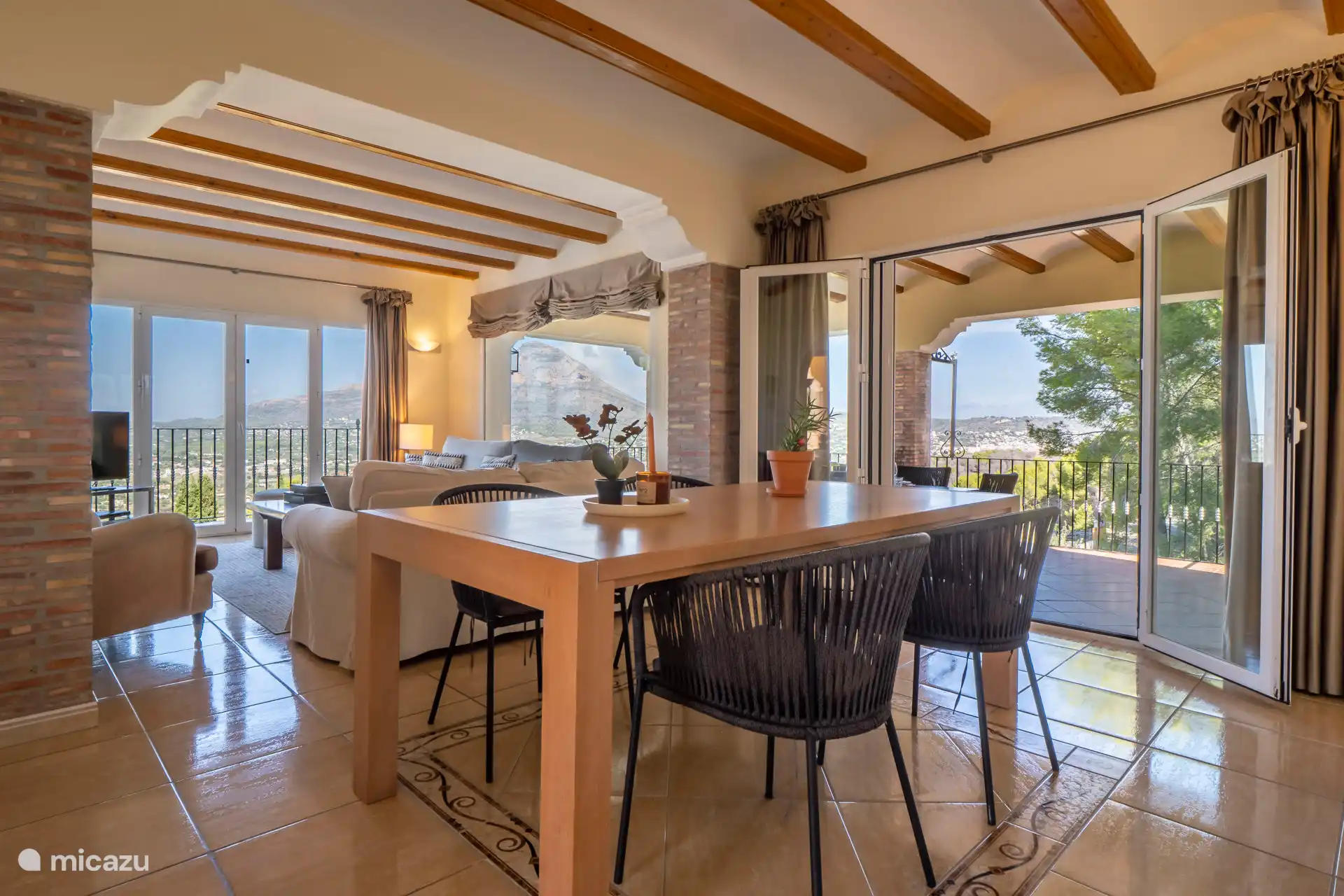 A beautiful bright living room with views over the green surroundings everywhere.