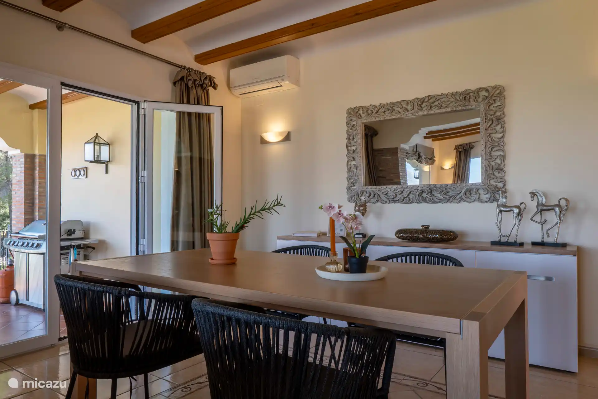 A dining area with patio doors to the terrace with barbecue