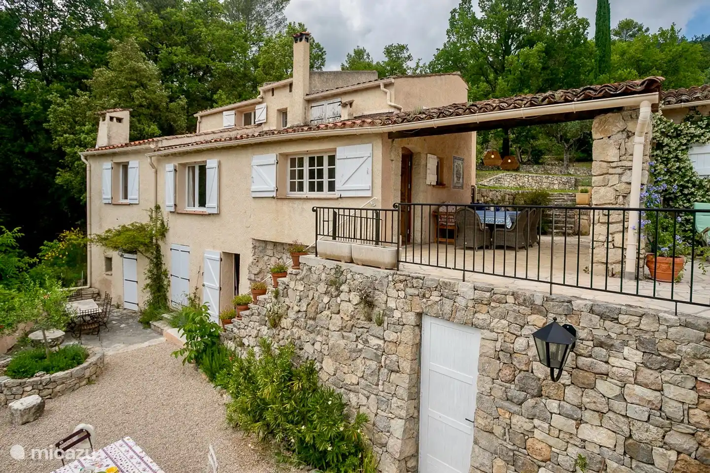 Het huis met het overdekte terras boven en het terras beneden 