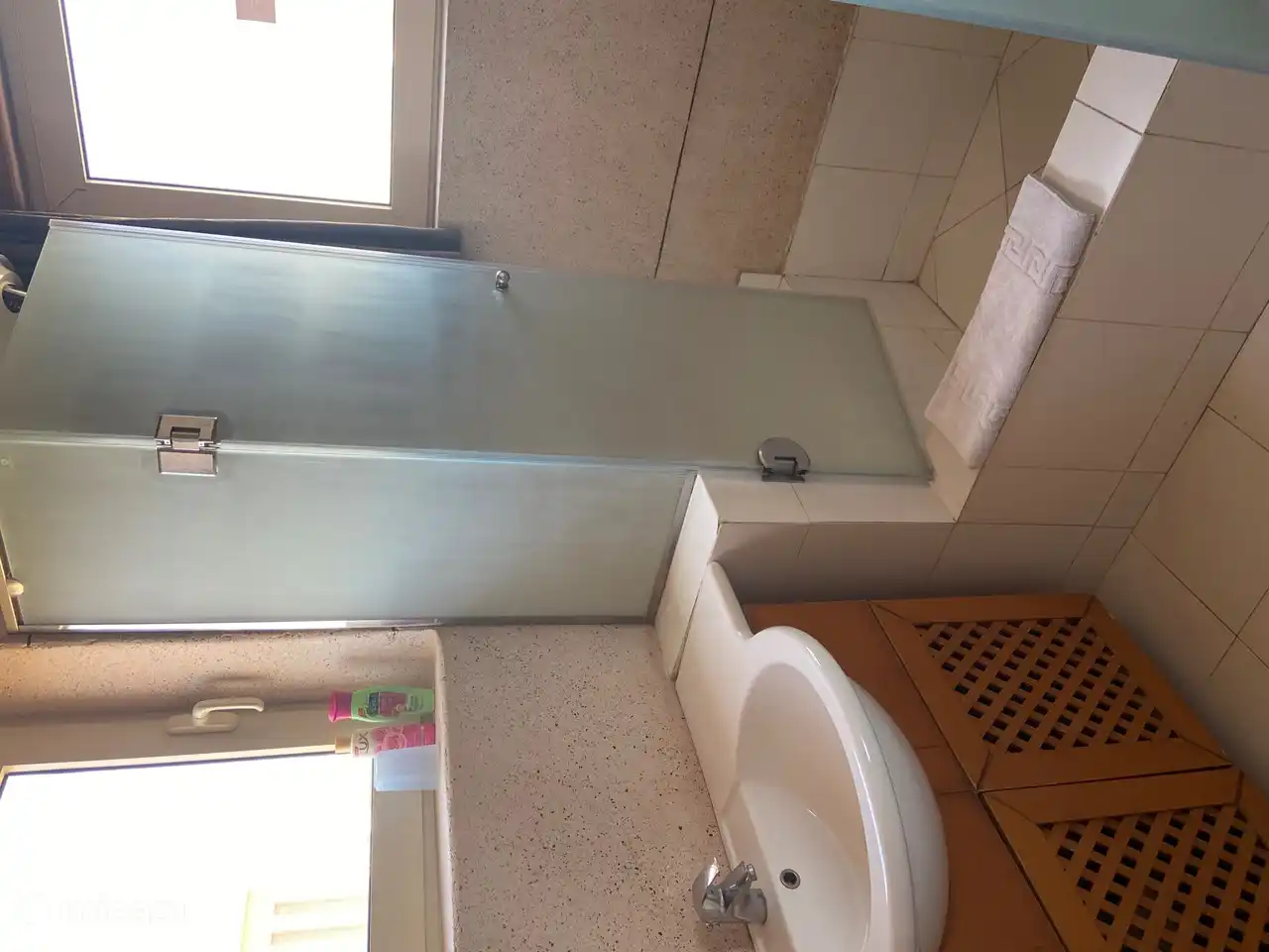 Bathroom with a large shower (high entry) sink and toilet.