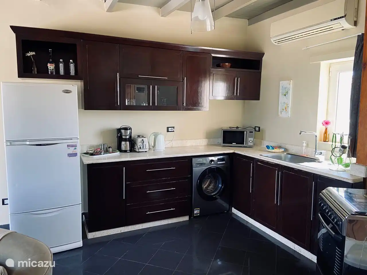Kitchen with gas stove / oven, combi microwave, kettle, toaster, coffee maker, fridge with freezer and a washing machine.