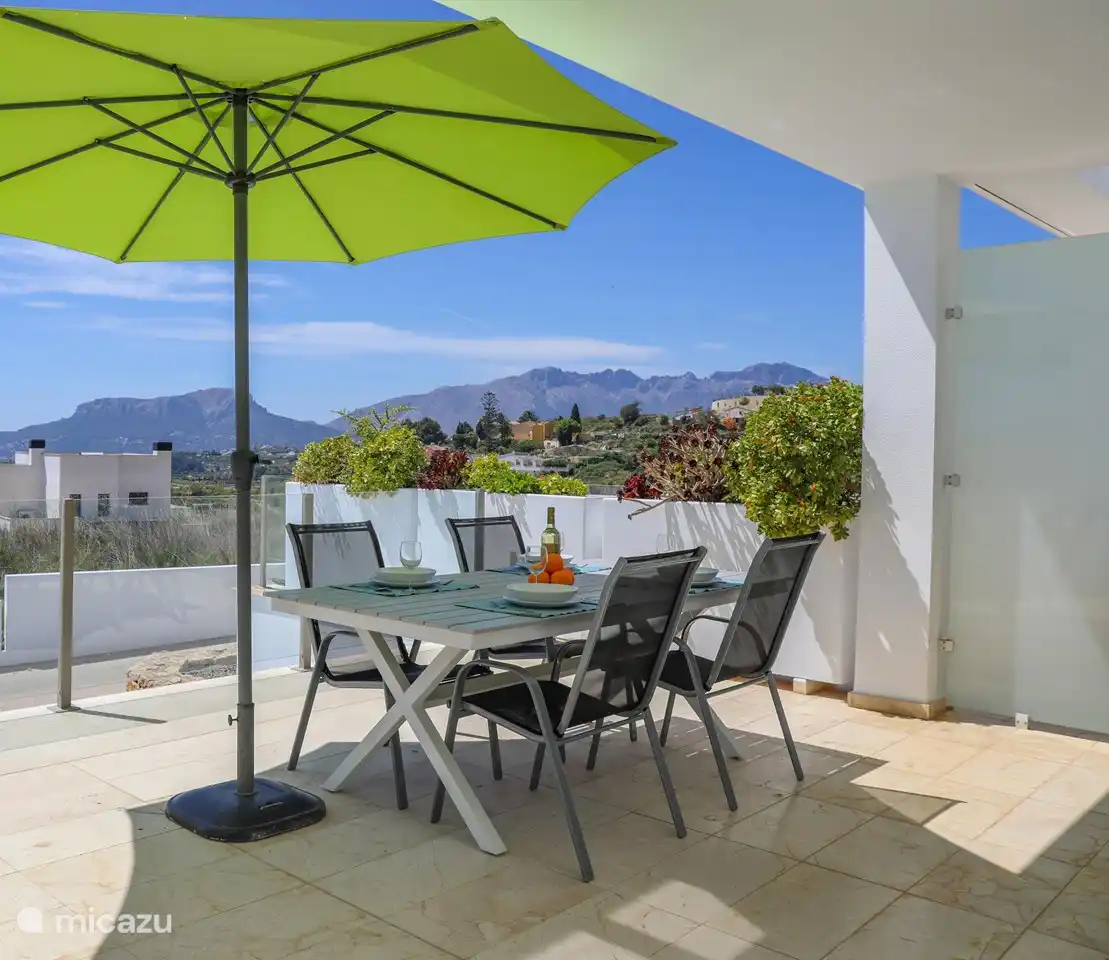Auf dem Balkon können Sie im Schatten unter dem Sonnenschirm sitzen