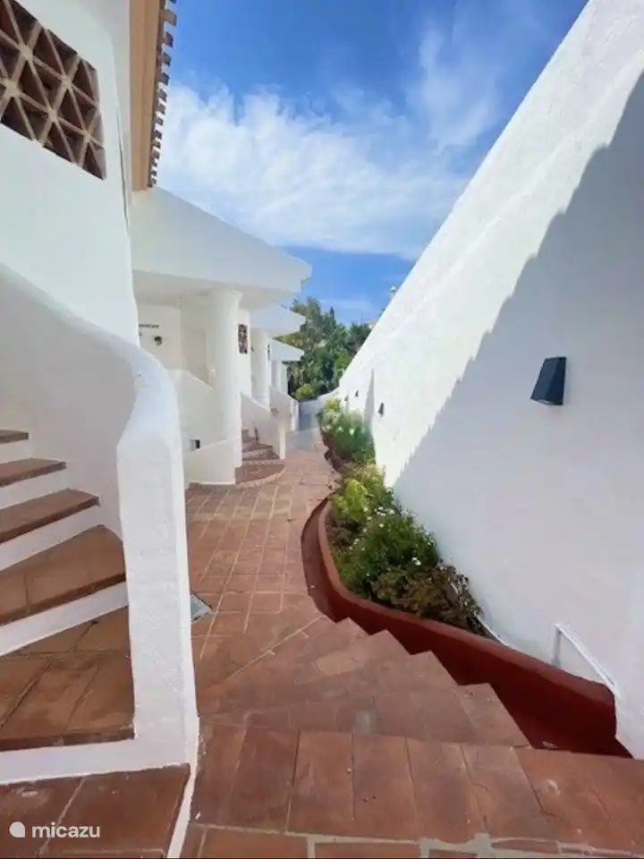 El exterior de la casa, colores t&#237;picos espa&#241;oles, blanco con terracota y mucha vegetaci&#243;n y buganvillas en el complejo.