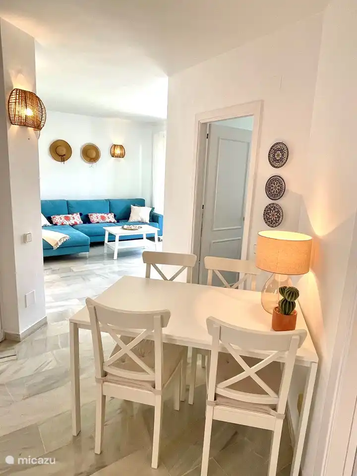 La sala de estar tiene una mesa de comedor en el medio. Al otro lado hay una amplia sala de estar y televisi&#243;n