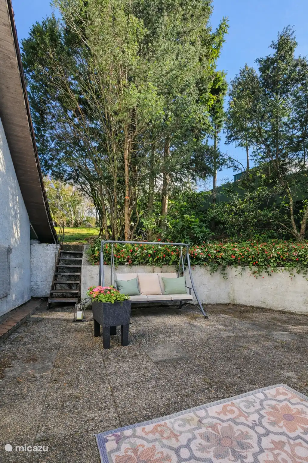Vanuit de woonkamer via de hal stap je het ruime terras op, omringt door groen en met prachtige vergezichten. Ontbijtje in de ochtendzon of met boek op de schommelbank.