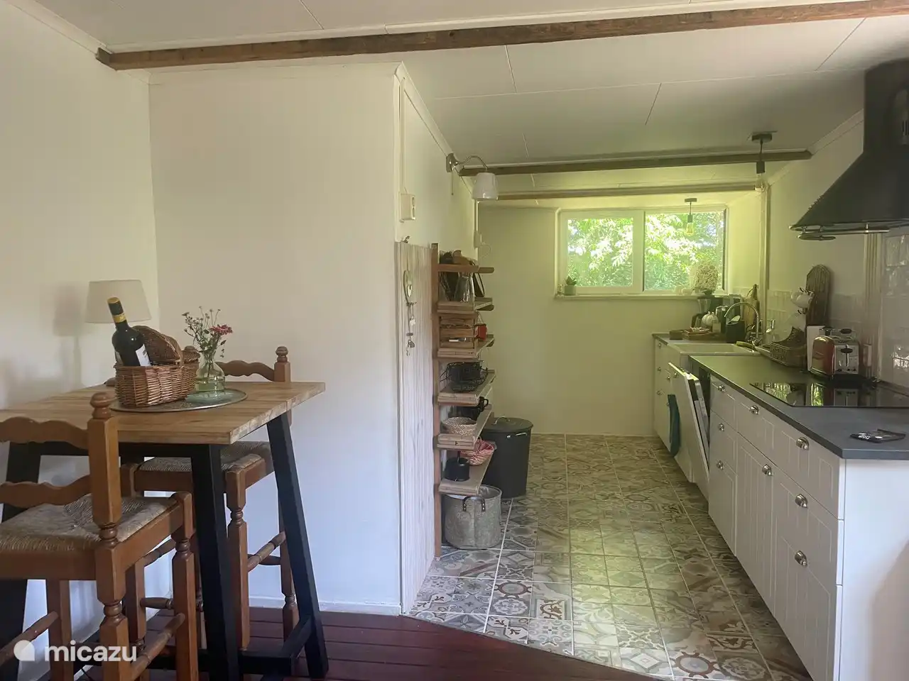 Keuken met zicht op groen en zitje. 