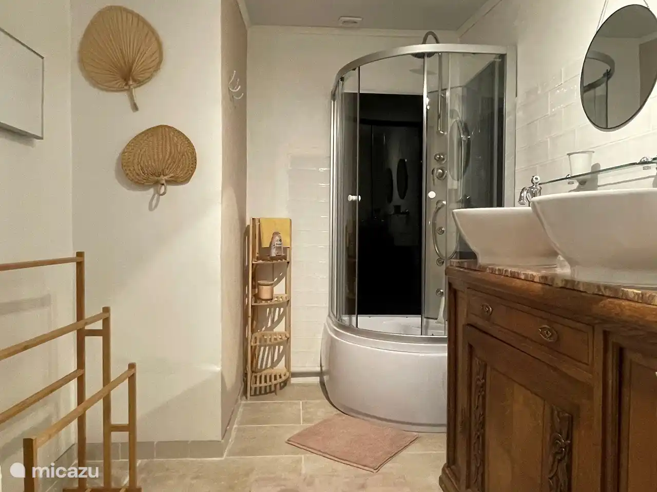 Badkamer met douchecabine en dubbele wastafel. 