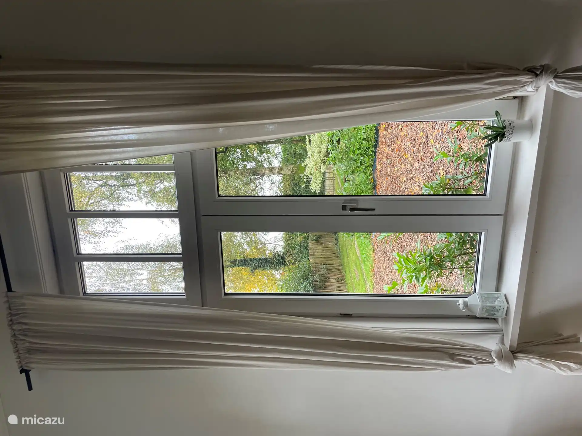 Zicht op de tuin met parkeervak. 