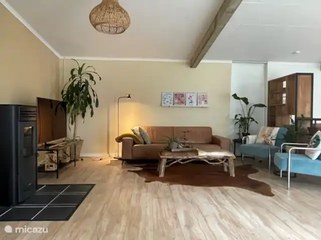 casa vacacional en Países Bajos, Barbante Septentrional, Molenschot – The Lazy Finch La zona de estar se calienta en los días más fríos con una estufa de pellets. Hay un precioso sofá de salón y sillones relax con otomana.
