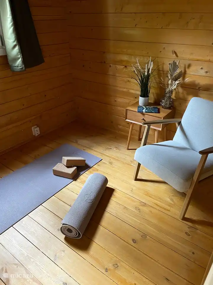 Ruheraum mit Yogamatten und bequemem Lesesessel. Auf Wunsch wird das Babybett hier aufgestellt.