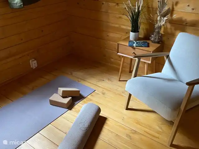 Woodhouse Eden en Países Bajos, Limburgo, Meijel - cabaña de madera Sala de relajación con colchonetas de yoga y cómoda silla de lectura. La cuna se colocará aquí si se solicita.